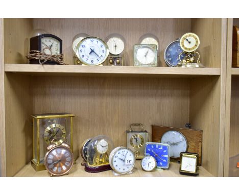 NINETEEN MANTLE AND BEDSIDE CLOCKS, to include four plastic domed rotating pendulum clocks, such as 'Kundo', 'Schatz &amp; So