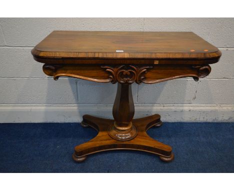 A VICTORIAN ROSEWOOD CARD TABLE, the fold over top enclosing a light green baize games surface, foliate carved decoration to 