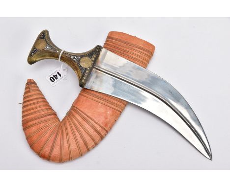 AN ARABIC JAMBIYA DAGGER AND SCABBARD, fitted with a carved animal horn handle, set with brass stud detailing and two medalli