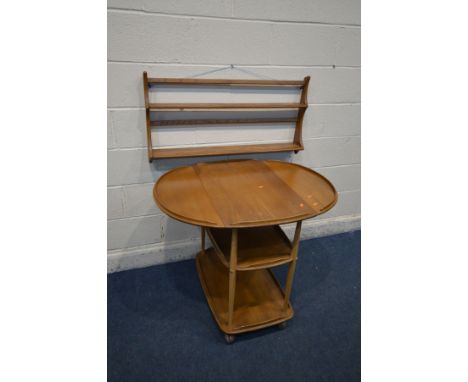 AN ERCOL MODEL 505 ELM AND BEECH DROP LEAF THREE TIER TEA TROLLEY, on orbit casters, open width 96cm x width 46cm x depth 74c