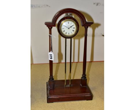 AN EARLY 20TH CENTURY PORTICO MYSTERY CLOCK, the mahogany archway frame with central brass uprights supporting a tortoise she