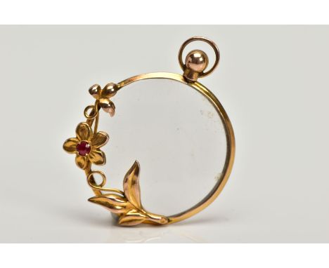 A 9CT GOLD RUBY SET PENDANT, double sided glass pendant of a circular form, decorated with a floral and foliate rim set with 