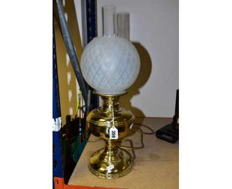 A BRASS BASED TABLE LAMP OF OIL LAMP FORM, with glass chimney and opaque glass shade, lack plug so not PAT rested, height to 