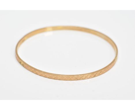 A 9CT YELLOW GOLD BANGLE, textured design all round, hallmarked 9ct gold Sheffield, approximate inner width 62mm, approximate