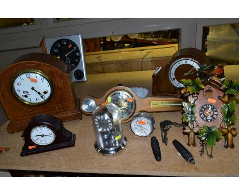 A SMALL GROUP OF SEVEN CLOCKS AND A MODERN BAROMETER, the clocks include an Edwardian mahogany, oak and inlaid dome top mante