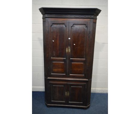 A LARGE OAK GEORGIAN FREESTANDING CORNER CUPBOARD, fixed cornice above double fielded panels doors enclosing three fixed shel