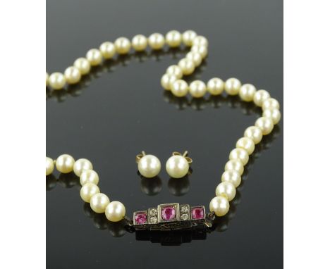 A string of cultured pearls with ruby and diamond set clasp in unmarked white metal setting, clasp length 21mm and a pair of 