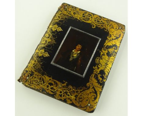 A Victorian papier-mache scrap album, the cover having an inset handpainted miniature portrait of a man in ornate gilded surr