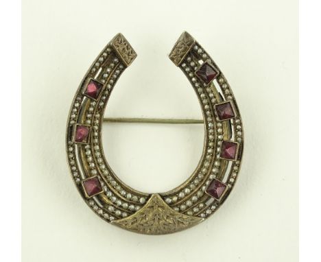 A continental silver seed pearl and square-cut garnet set horseshoe brooch, continental hallmarks, height 50mm.