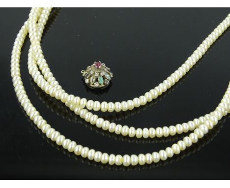 A triple strand simulated pearl necklace and a gemstone set silver pendant.