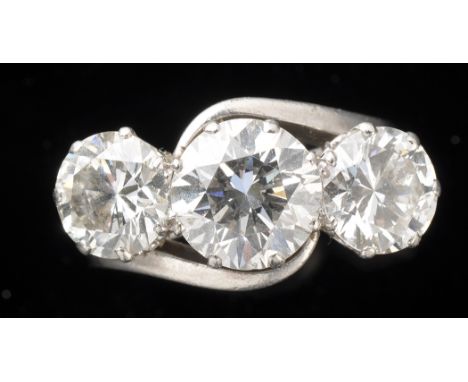 A three stone diamond ring, the central old European cut diamond measuring 8.15 x 8.9 x 5.4mm, estimated to weight approximat