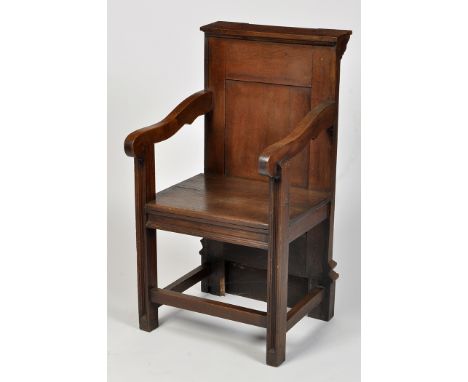 A 19th Century prayer chair, the inverted breakfront cresting rail above panel back inlaid 'IHS', flanked by shaped open arms