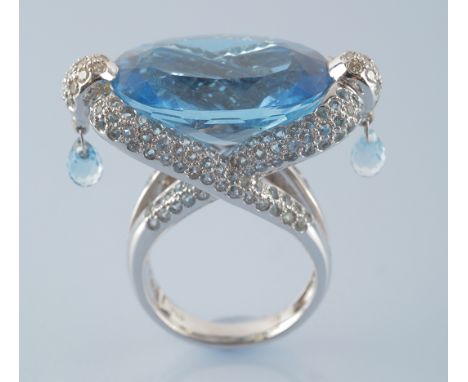 A topaz and diamond dress ring, the oval facet cut blue topaz measuring 22 x 15.5 x 9.8mm, estimated to weigh approximately 2