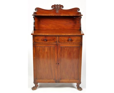 An early 19th Century mahogany chiffonier, the scrolling and carved back fitted a shelf on shaped support, the base fitted tw