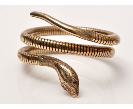 A Victorian style 9ct. yellow gold snake pattern bangle, with metal core, ruby set eyes and engraved head, 5.5cms wide (but e