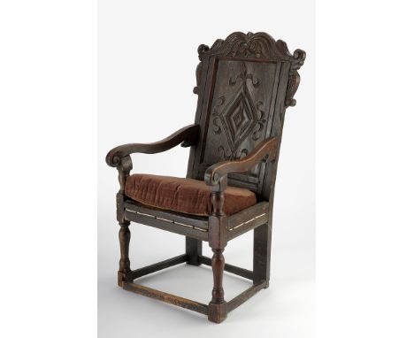 An 17th/18th Century joined oak Yorkshire chair, the central diamond-motif carved back panel surrounded by leaf scrolls, flan