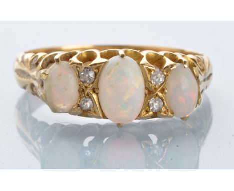 An opal and diamond ring, the three graduated oval opal cabochons separated by rose-cut diamonds, in openwork scrolling mount