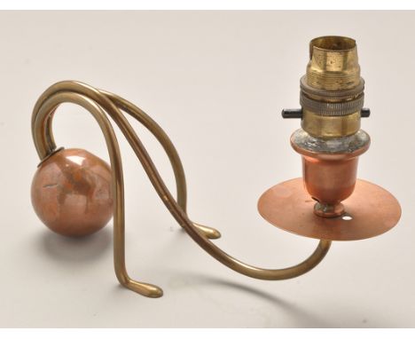Carl Deffner: a copper and brass candlestick, the sconce converted to electricity, on brass scroll feet and copper orb weight