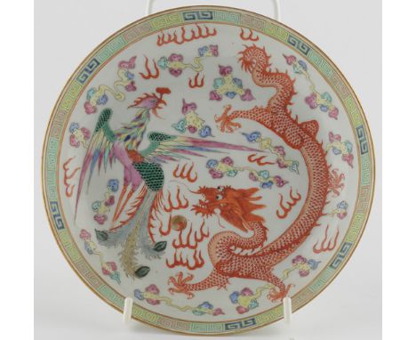 Chinese Famille Rose saucer dish, with dragon chasing flaming pearl beside Phoenix with out stretched wings amongst cloud scr