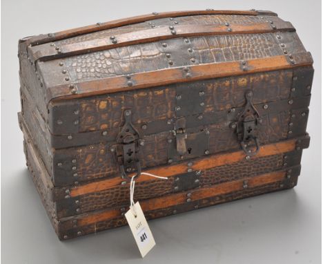 An early 20th Century miniature dome top trunk, covered in reptile skin pattern embossed leather, with stained wood and metal