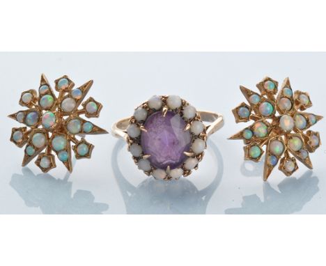 An amethyst and opal cluster ring, the oval facet cut amethyst surrounded by opal cabochons, the yellow metal shank stamped '