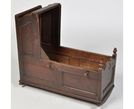 An 18th Century oak cradle, with panel sides, 81 x 45 x 76cms (32 x 17 x 30in.).