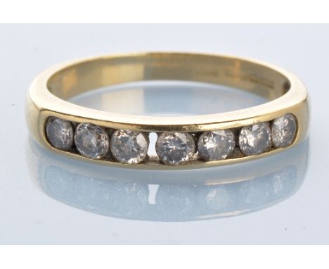 A seven stone diamond ring, the brilliant cut diamonds weighing a total of approximately 0.40 carats, in channel setting, 18c