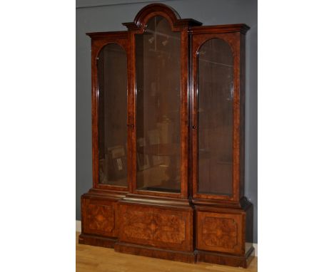A Victorian burr walnut breakfront bookcase, with central arch above flared cornice, fitted three glazed panel doors enclosin