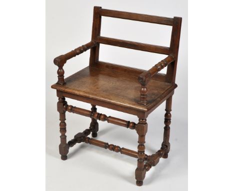 An 18th Century and later open armchair, the ladder back (reduced) flanked by turned arms, the solid elm seat raised on turne