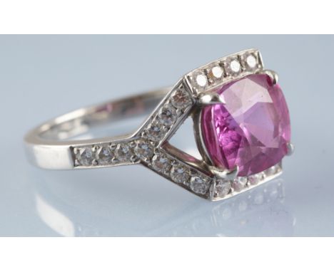 Tiffany & Co: a pink sapphire and diamond dress ring, the oval facet cut pink sapphire measuring 9.4 x 8.6 x 5.9mm, estimated