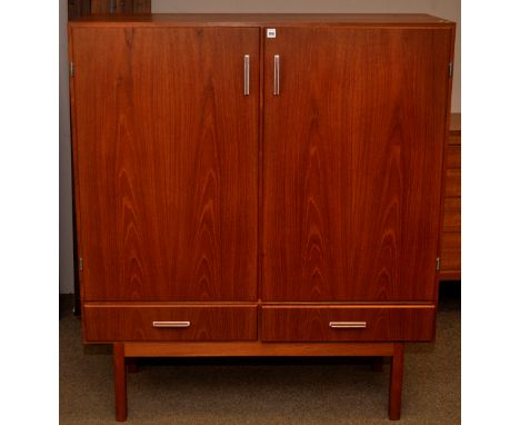 Axel Christensen, Denmark: a teak drinks cabinet, the plain panel doors opening to reveal mirror back and bottle receivers, w