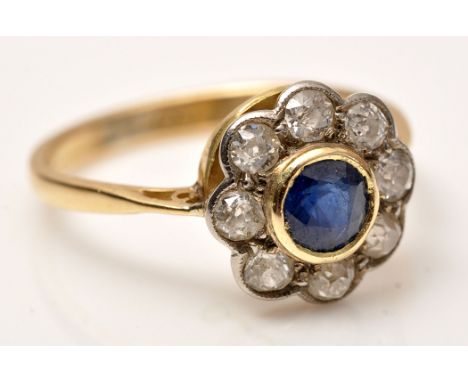 A sapphire and diamond cluster ring, the circular facet cut sapphire in collet setting surrounded by eight old cut diamonds i