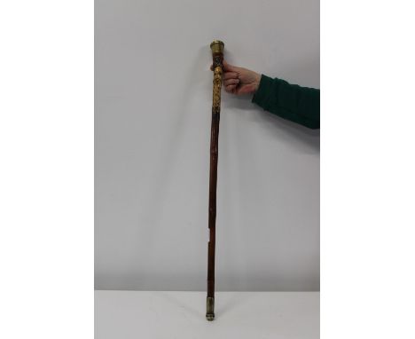 A nicely carved walking stick with brass fittings 