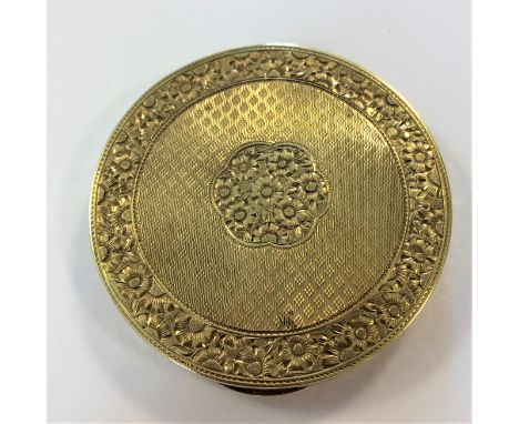 of circular form, 6cm diameter, the piano hinged slightly convex cover decorated with engine turned engraving within a foliat