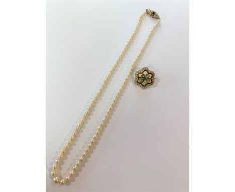 the first, a string of cultured pearls graduating from 3.5 to 7mm, yellow metal clasp set with a garnet and six pearls, stamp