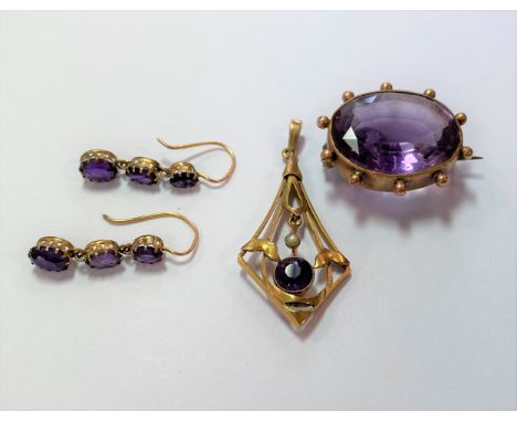 the first, an oval brooch with an oval faceted amethyst set within a beaded border, pin and hook fitting, dimensions, 2.5 x 2
