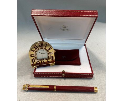 the clock with signed arch topped white dial, blued hands and gold coloured alarm pointer, arch top gold-plated brass case wi