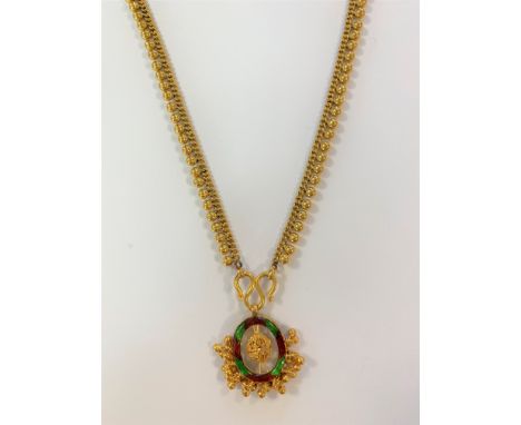 of Indian origin and possibly a bridal jewel, the oval shaped centrepiece with green and red enamel decoration and lower frin