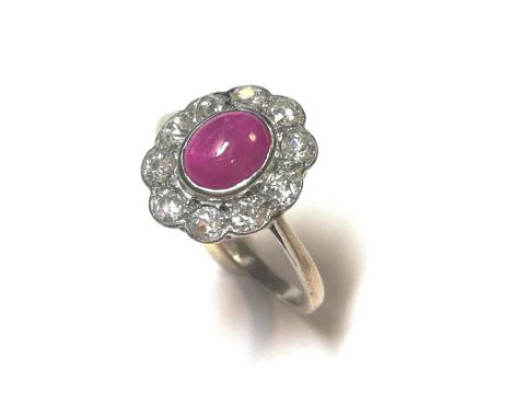 central rubover set oval cabochon pinkish red ruby, 6.8 x 5.6mm, surrounded by ten rubover set old brilliant cut diamonds, es