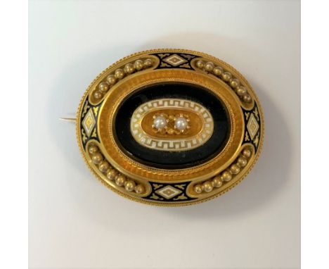 two claw set central pearls surrounded by a white enamel border with gold Greek key decoration in turn surrounded by a plain 