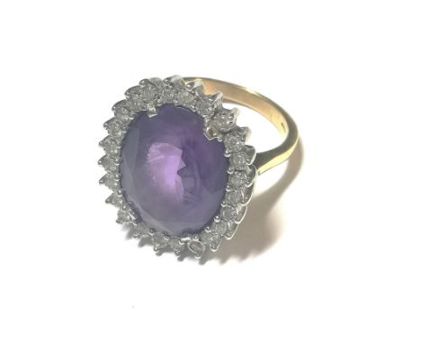 central claw set oval faceted amethyst, 20 x 15mm, surrounded by twenty four illusion set round brilliant cut diamonds, estim