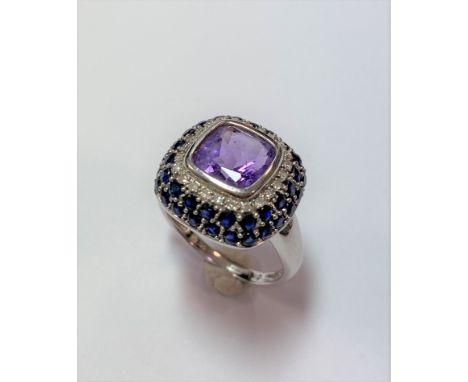 central cushion faceted amethyst rubover set to a cushion curved border composed of one row of eight cut diamonds and two row