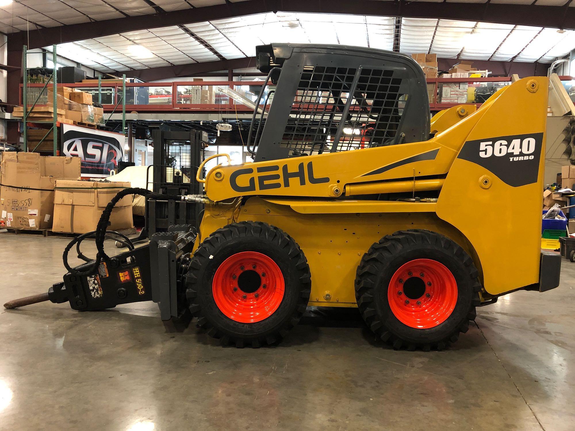 GEHL 5640 TURBO SKID STEER W/ HAMMER ATTACHMENT, 82 HP (61KW), NEW RIMS