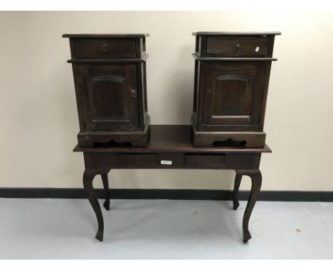 A contemporary hardwood two-drawer console table together with a pair of bedside cabinets with panel doors