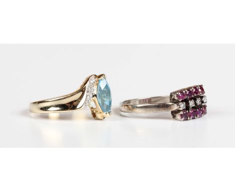 A gold, blue topaz and diamond ring in a crossover design, mounted with a marquise shaped treated blue topaz to the centre, d