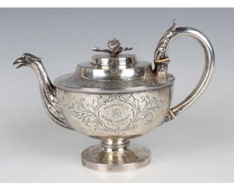 A George III silver circular teapot with flower finial above engraved foliate decoration, the front inscribed with a monogram