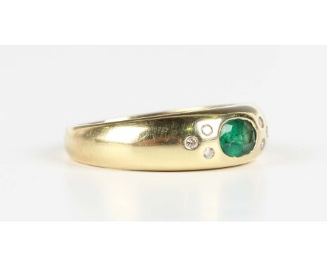 A gold, emerald and diamond ring, mounted with an oval cut emerald between circular cut diamond three stone sides, detailed '