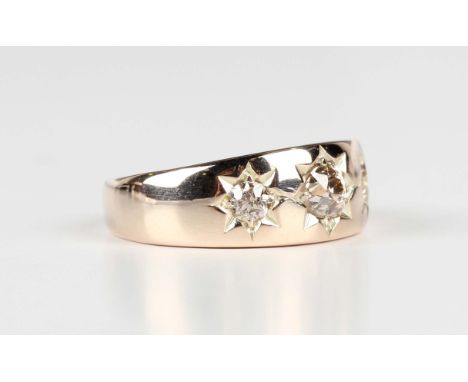 A gold and diamond three stone ring, star gypsy set with cushion cut diamonds, the principal diamond mounted to the centre, d