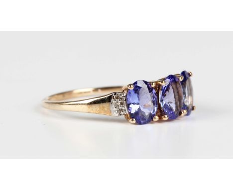 A 9ct gold ring, claw set with three oval cut tanzanites between diamond three stone shoulders, Birmingham 2013, weight 2.4g,