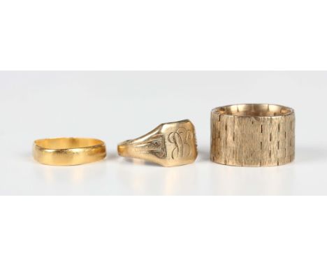 A 22ct gold wedding ring, Birmingham 1911, weight 1.6g (distorted), a 9ct gold wide band ring with textured decoration and a 